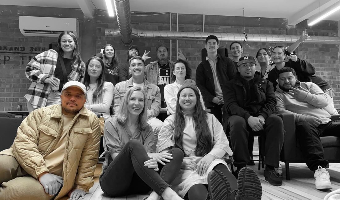 A group photo of the In The Flow State community in a brick-walled room
